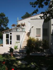 een wit huis met een trap en een balkon bij JAS en Provence in Plan dʼAups
