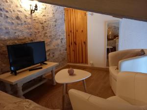 sala de estar con TV y sofá en La charentaise ch d'hôtes ,Studio, en Chérac