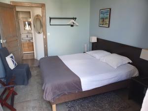 1 dormitorio con 1 cama grande y 1 silla en Le Bistrot Vinaigrette, en Prades-le-Lez