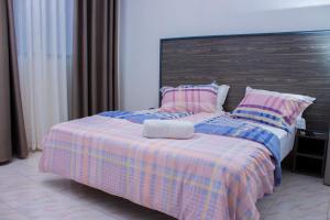 - un lit avec une couverture et des oreillers dans l'établissement Van Der Salle - Flovan Plaza, à Haatso