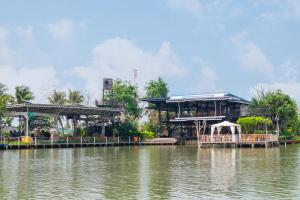 un ristorante sul lato di un bacino d'acqua di Feel like home แบบบ้านบ้าน a Talat Amphoe Nakhon Chai Si