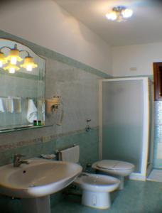 La salle de bains est pourvue d'un lavabo, de toilettes et d'un miroir. dans l'établissement Araba Fenice Hotel, à San Vito Lo Capo
