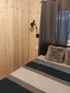 a bedroom with a bed with a blanket and a lamp at Domek nad stawem in Robakowo