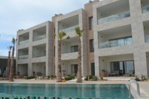 a building with a swimming pool and palm trees at Dakhla South Bay in Dakhla