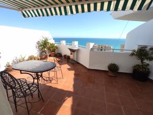 een balkon met een tafel en stoelen en de oceaan bij Penthouse Near The Beach in Fuengirola