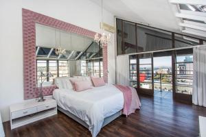 a bedroom with a large bed and large windows at Manhattan Lofts in Cape Town