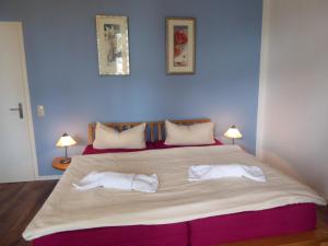 a bedroom with a large bed with two towels on it at Zum Donnerkeil in Göhren