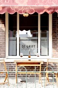 einen Tisch und zwei Stühle vor einem Fenster in der Unterkunft De Grift in Apeldoorn