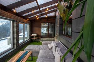 a screened in porch with couches and windows at Apart-hotel Vershina in Yaremche