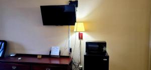 Habitación de hotel con TV y escritorio con TV. en Regency Travel Inn, en Hayti