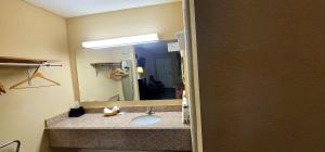 baño con lavabo y espejo grande en Regency Travel Inn, en Hayti