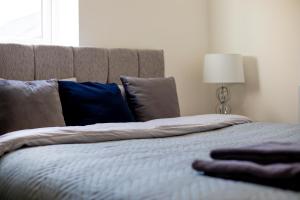 a bedroom with a bed with blue pillows at Sigma Executive Apartment 6 in North Shields