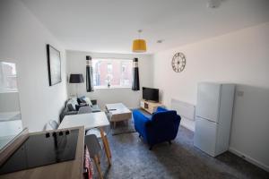 a living room with a desk and a refrigerator at Sigma Executive Apartment 6 in North Shields +17 photos