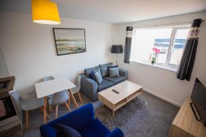 a living room with a blue couch and a table at Sigma Executive Apartment 6 in North Shields