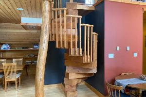 a wooden spiral staircase in a room with a table at Gudjonson Getaway - 2 bed 2 bath Cabin in Golden