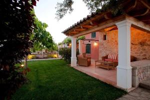 a patio with a couch and a table in a yard at Can Cremat in Port de Pollensa