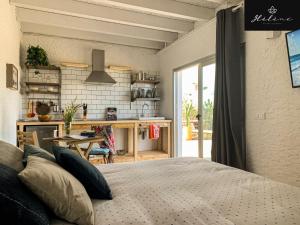 een slaapkamer met een bed en een keuken met een tafel bij Hélène Holidays - Hotel Boutique in Corralejo