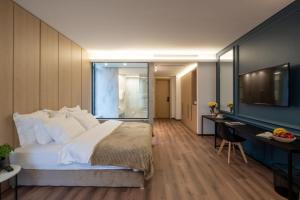 een slaapkamer met een bed, een bureau en een televisie bij VOTRE hotel in Jounieh