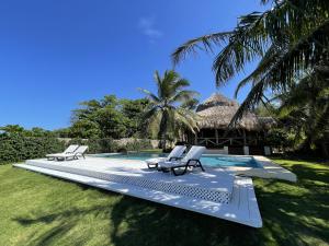 ein Pool mit 2 Liegestühlen und ein Resort in der Unterkunft hacienda del mar in Río San Juan