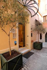 un bâtiment avec un arbre devant un bâtiment dans l'établissement Residence Arco Antico, à Syracuse