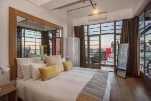 a bedroom with a large white bed and large windows at Manhattan Lofts in Cape Town +50 photos