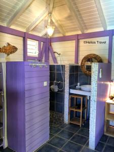 a bathroom with a purple door and a sink at Villa Deshaies in Deshaies