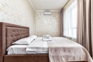 a bedroom with a bed with two towels on it at Апартаменты Променад экспо 269 in Astana