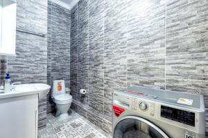 een wasmachine in een badkamer met toilet bij Апартаменты Променад экспо 269 in Astana +8 foto's
