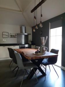 a dining room with a wooden table and chairs at Luxe chalet Beekbergen nl in Beekbergen