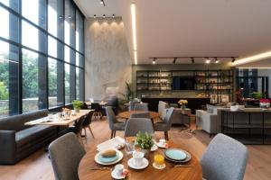 a restaurant with tables and chairs and windows at VOTRE hotel in Jounieh