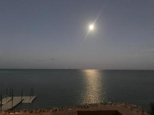 a full moon over the water with a dock at Dakhla South Bay in Dakhla