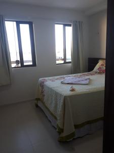 ein Schlafzimmer mit einem Bett und zwei Fenstern in der Unterkunft Apartamento Condomínio Sonhos da Serra - Bananeiras in Bananeiras