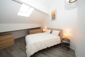 a bedroom with a white bed and a skylight at Dune des Landes in Lacanau-Océan