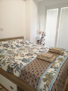 a bed with a comforter on it in a bedroom at Enjoy Apartments Karamach in Ohrid