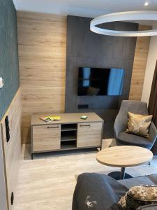 uma sala de estar com uma televisão e uma mesa em Apartment 1 em Zella-Mehlis