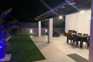 a patio with a table and chairs and a couch at Amazing house close to the beach in Port d'Alcudia