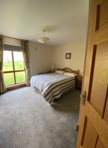 a bedroom with a bed and a large window at 4 The Mews in Athlone