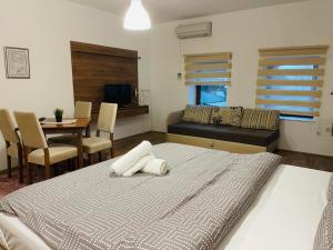 a bedroom with a bed and a dining room at Fuk-tak apartmani&restoran in Star Dojran