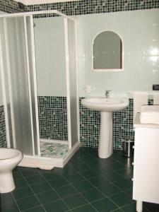 La salle de bains est pourvue d'un lavabo, d'une douche et de toilettes. dans l'établissement B&B Minerva, à Castro di Lecce