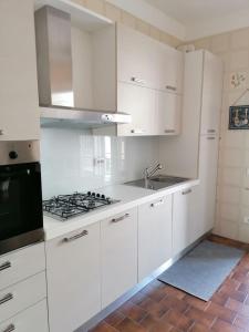 a white kitchen with a sink and a stove at La Casetta al 21 in Matera