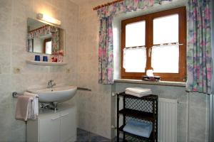 een badkamer met een wastafel en een raam bij Ferienwohnung Lauer in Schönau am Königssee