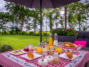 una mesa de picnic con comida y bebida y una sombrilla en Vakantiewoningen Prelude & Etude, en Wieringerwaard