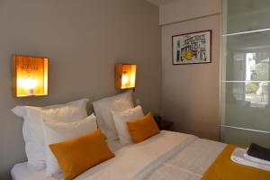 a bedroom with a bed with orange and white pillows at Casotas in Lisbon
