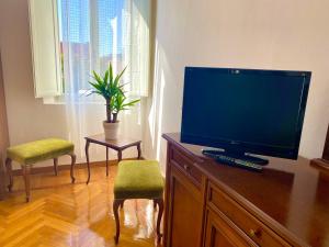 a flat screen tv sitting on top of a wooden dresser at Al Fluviale in Ferrara