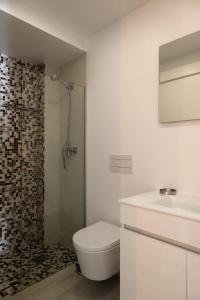 uma casa de banho com um chuveiro, um WC e um lavatório. em Casotas em Lisboa