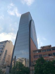 um alto edifício de escritórios de vidro em uma cidade em HOTEL CHACAO SUITES em Caracas