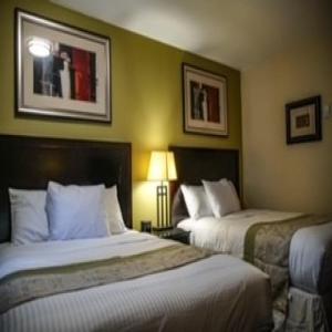 a hotel room with two beds and two pictures on the wall at Skyland Motel Inn & Suites in Huntsville