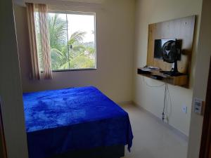Casa Duplex Iriri - Banheira e Piscina في إيريري: غرفة نوم بسرير ازرق ونافذة