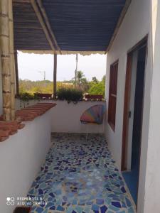 um quarto com uma varanda com uma cadeira no chão em Los Versos de Zaira em San Onofre