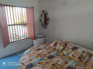 1 dormitorio con cama y ventana en Los Versos de Zaira en San Onofre